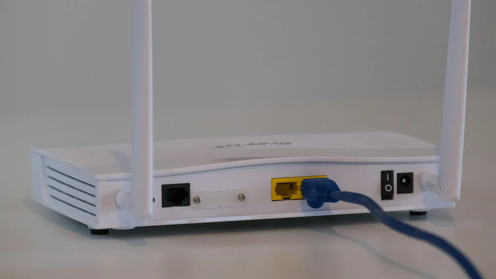A white internet router with a network cable plugged in
