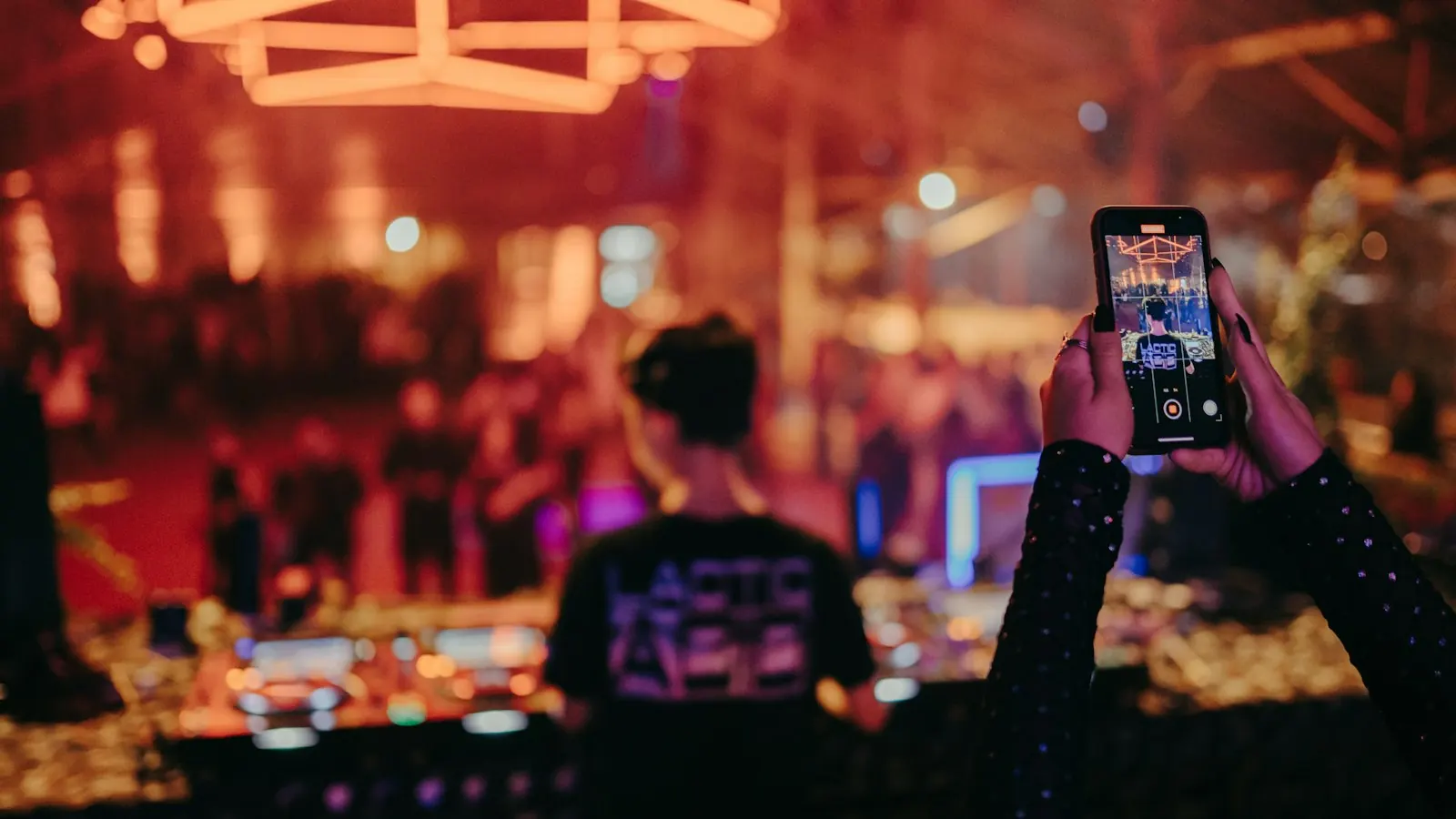 A guest takes a photo with a phone at a party