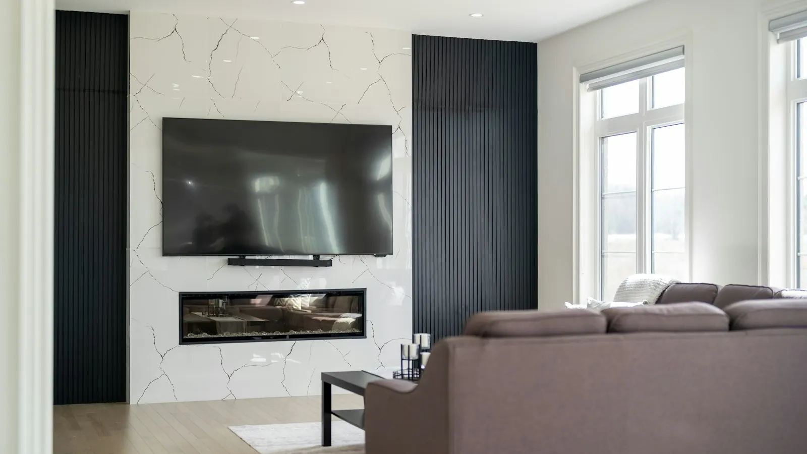 A large TV mounted on the wall above a fireplace